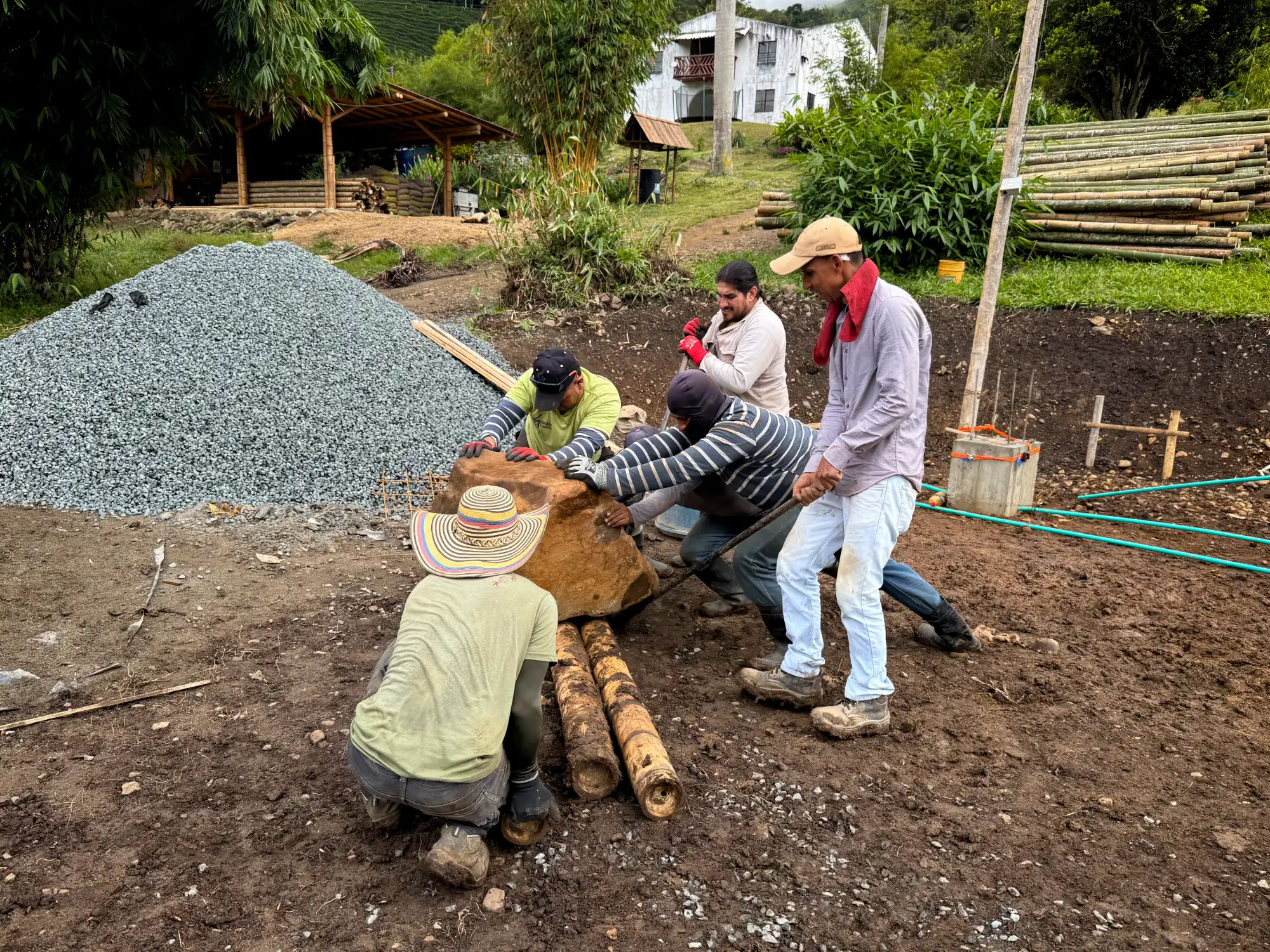 Moving rocks on bamboo poles at the construction site