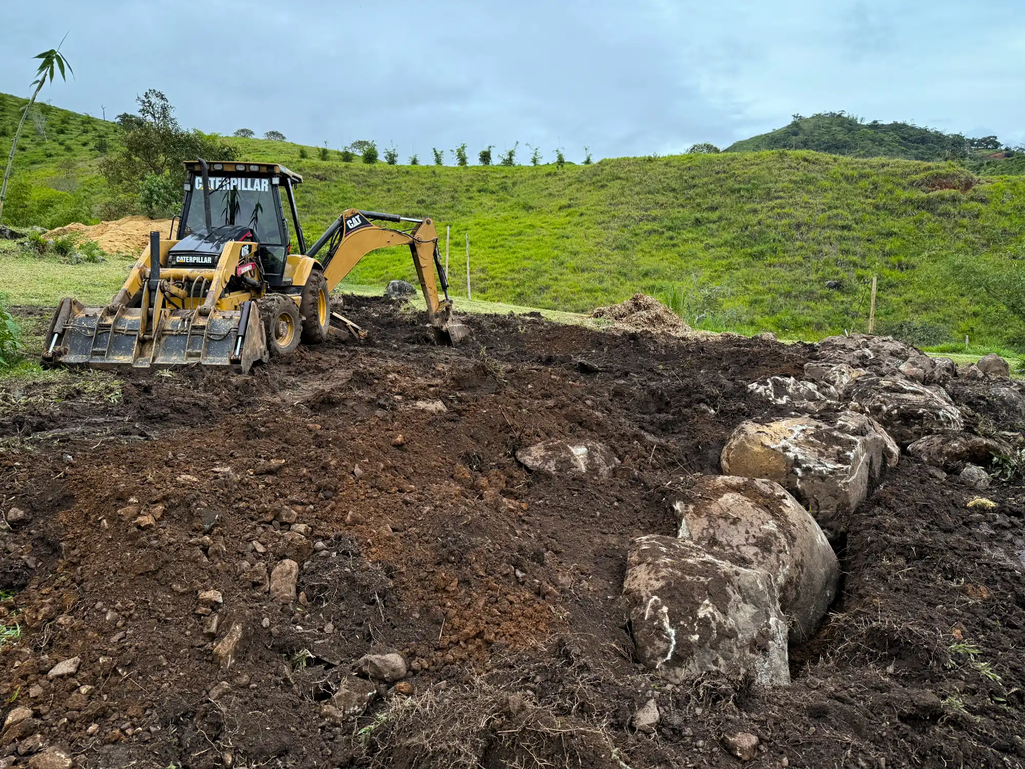 Excavation with backhoe for bamboo pavilion foundation