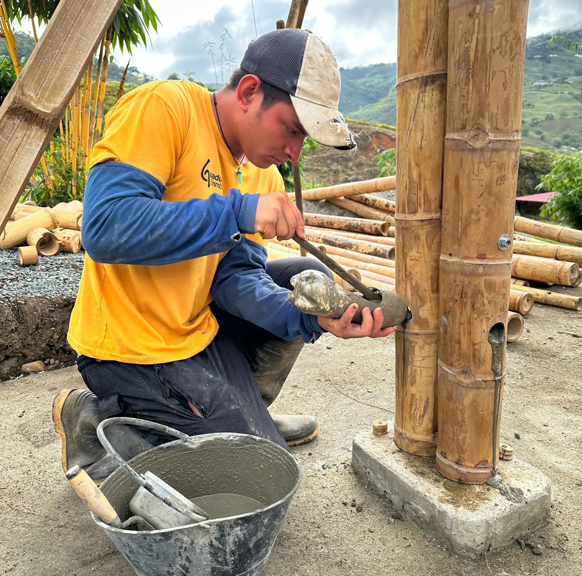 Builder filling Guadua bamboo internodes with mortar