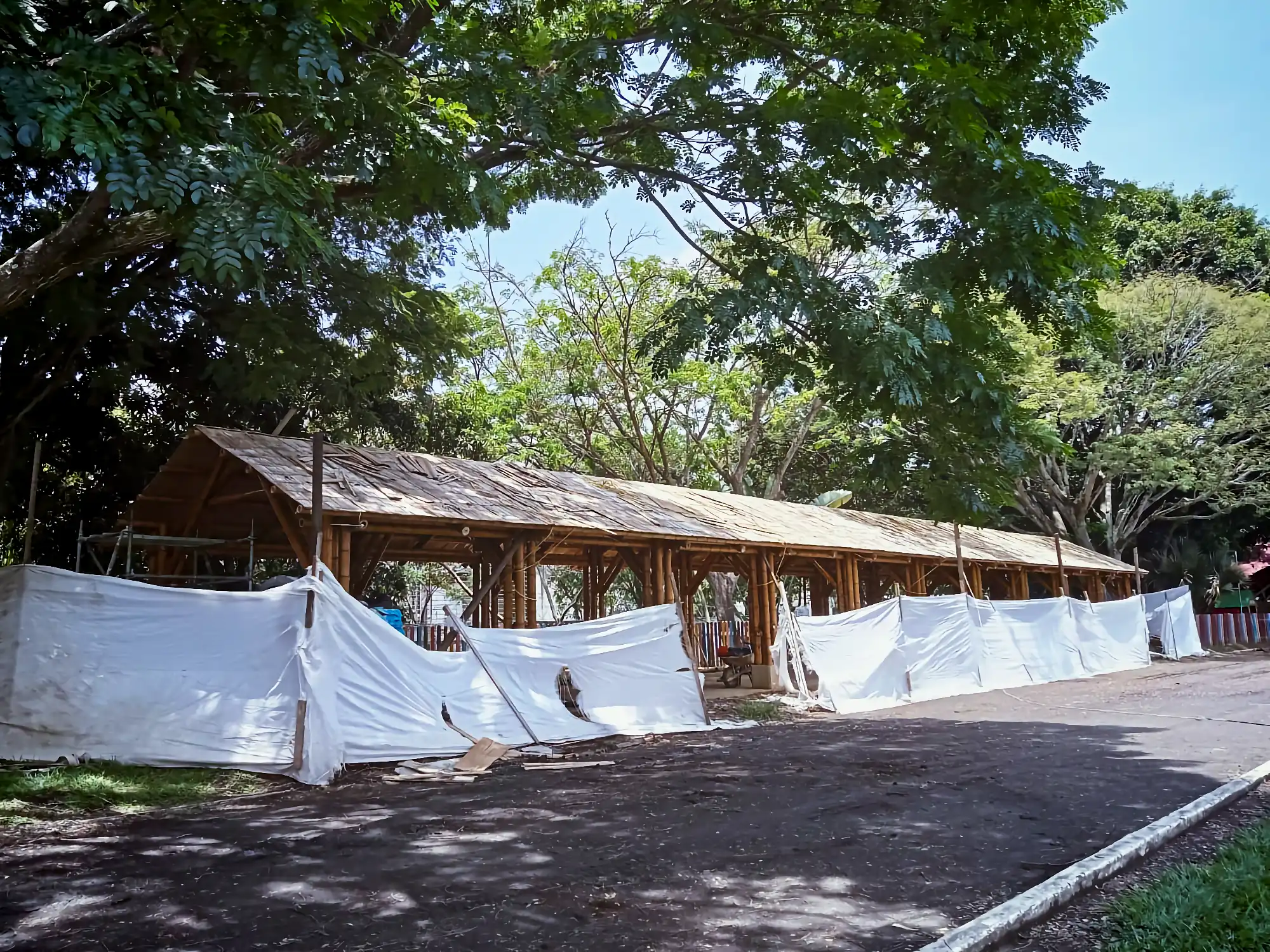 Installing flattened bamboo mats (esterilla) over the rafter structure for the roof deck