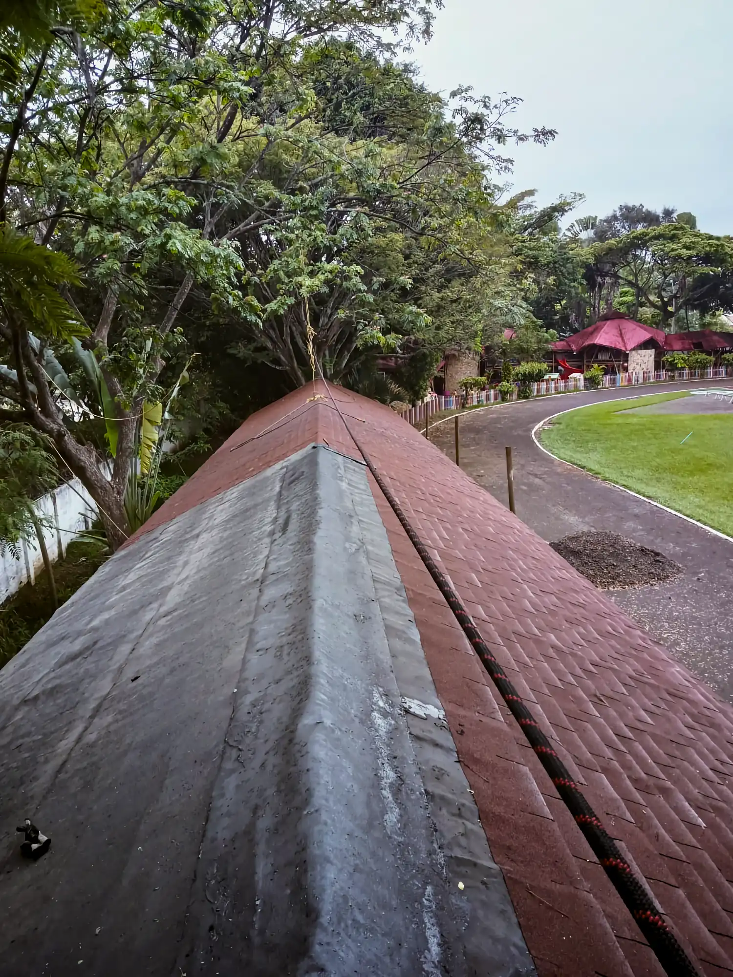 Installing asphalt roof shingles over the prefabricated bamboo structure