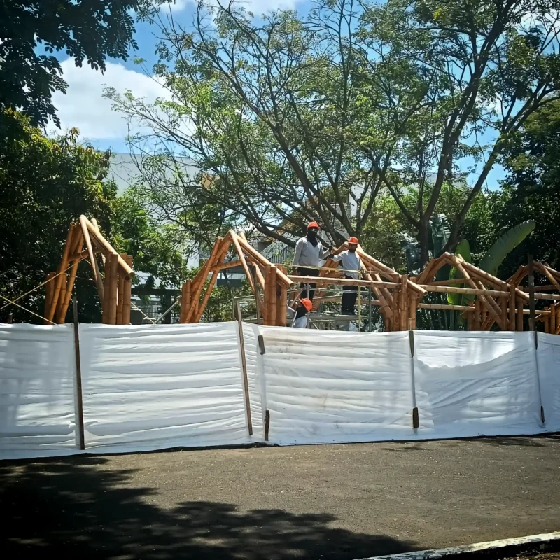 Installing the Guadua bamboo roof rafters and bracing over the prefabricated structure