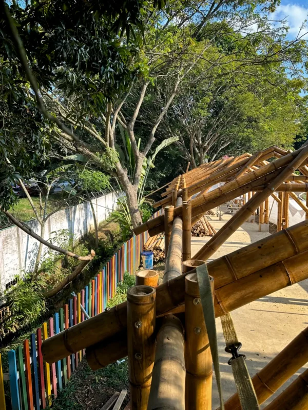 Installing the Guadua bamboo roof rafters and bracing over the prefabricated structure
